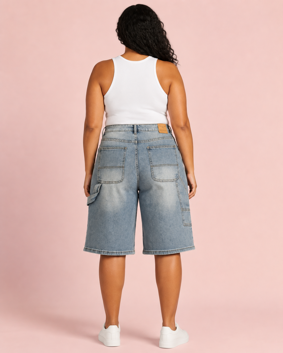 Plus-size model wearing light-wash utility denim Bermuda shorts, back view