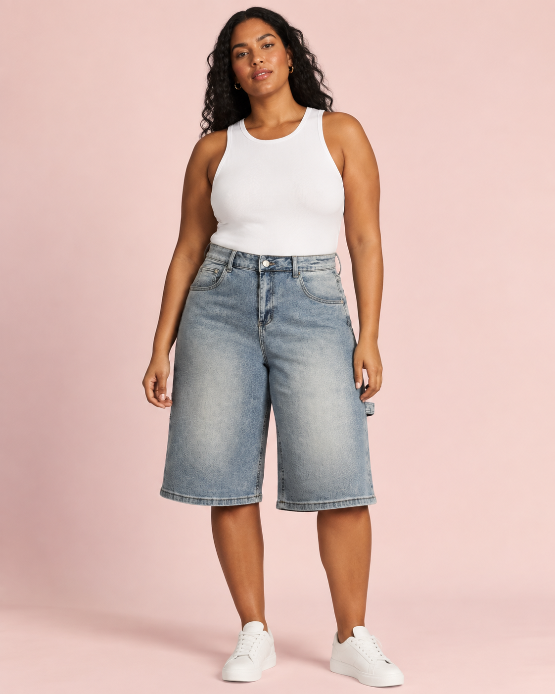 Plus-size model wearing light-wash wide-leg denim Bermuda shorts, front view.