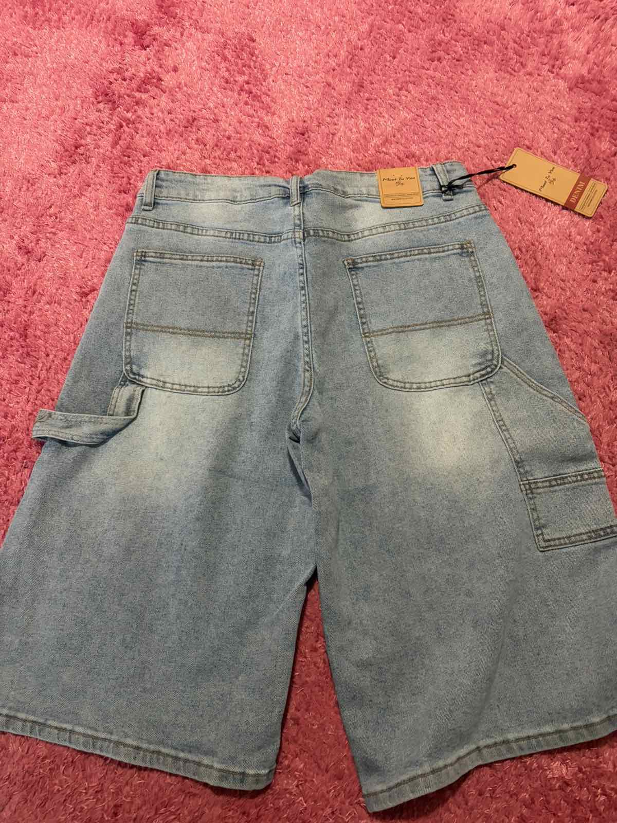 Back view of light-wash denim Bermuda shorts with utility pockets